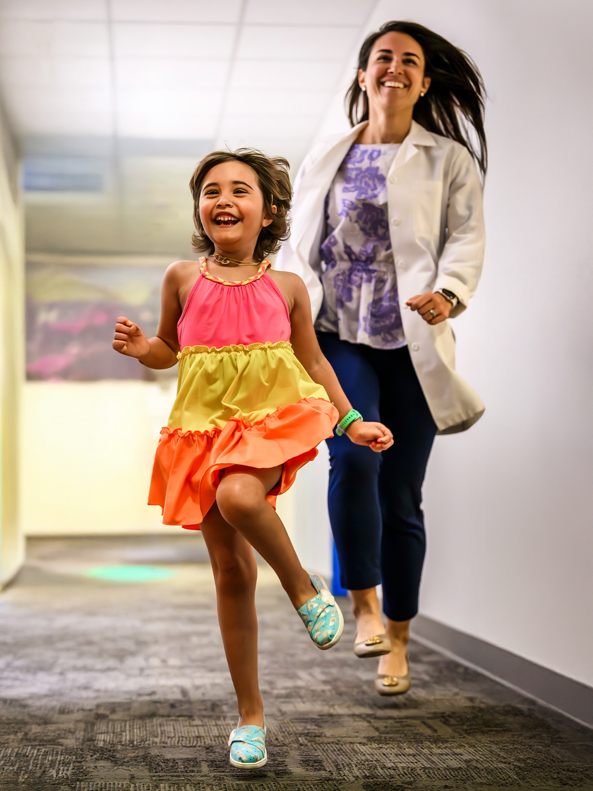 A provider and a child running down a hallway.